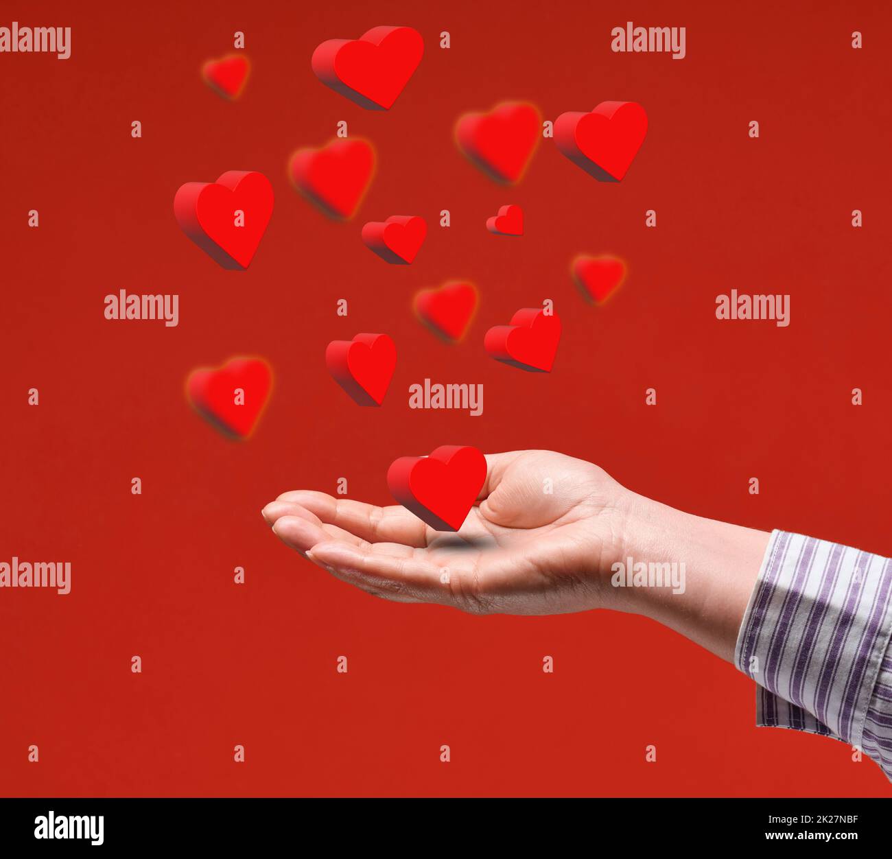 Weibliche Hand und rote fliegende Herzen auf rotem Hintergrund. Alles Liebe zum Valentinstag Stockfoto