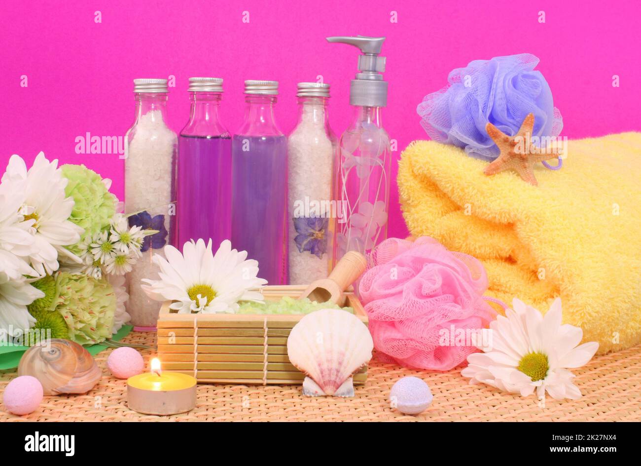 Bad- und Wellnessprodukte mit Blumen auf rosafarbener Seife Stockfoto