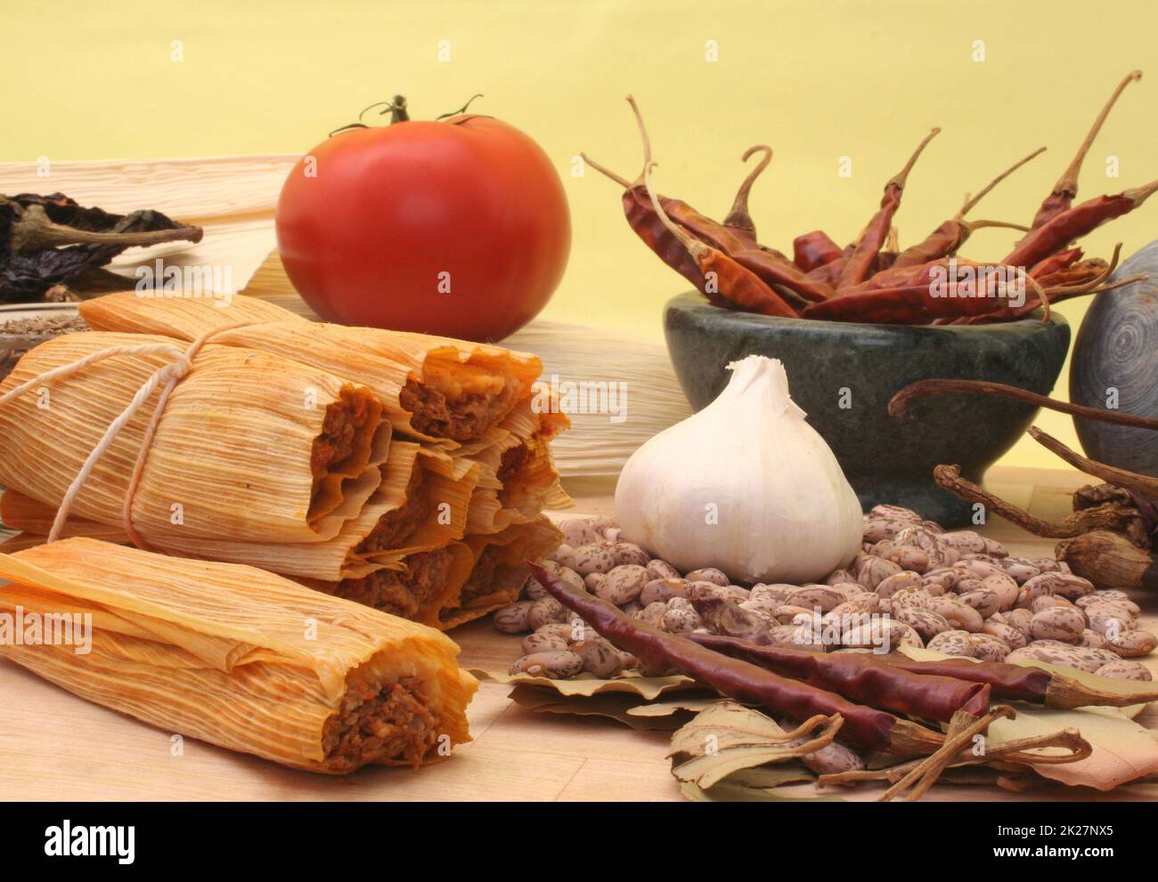 Tamales mit Knoblauch, Bohnen und Tomate auf gelbem Hintergrund Stockfoto