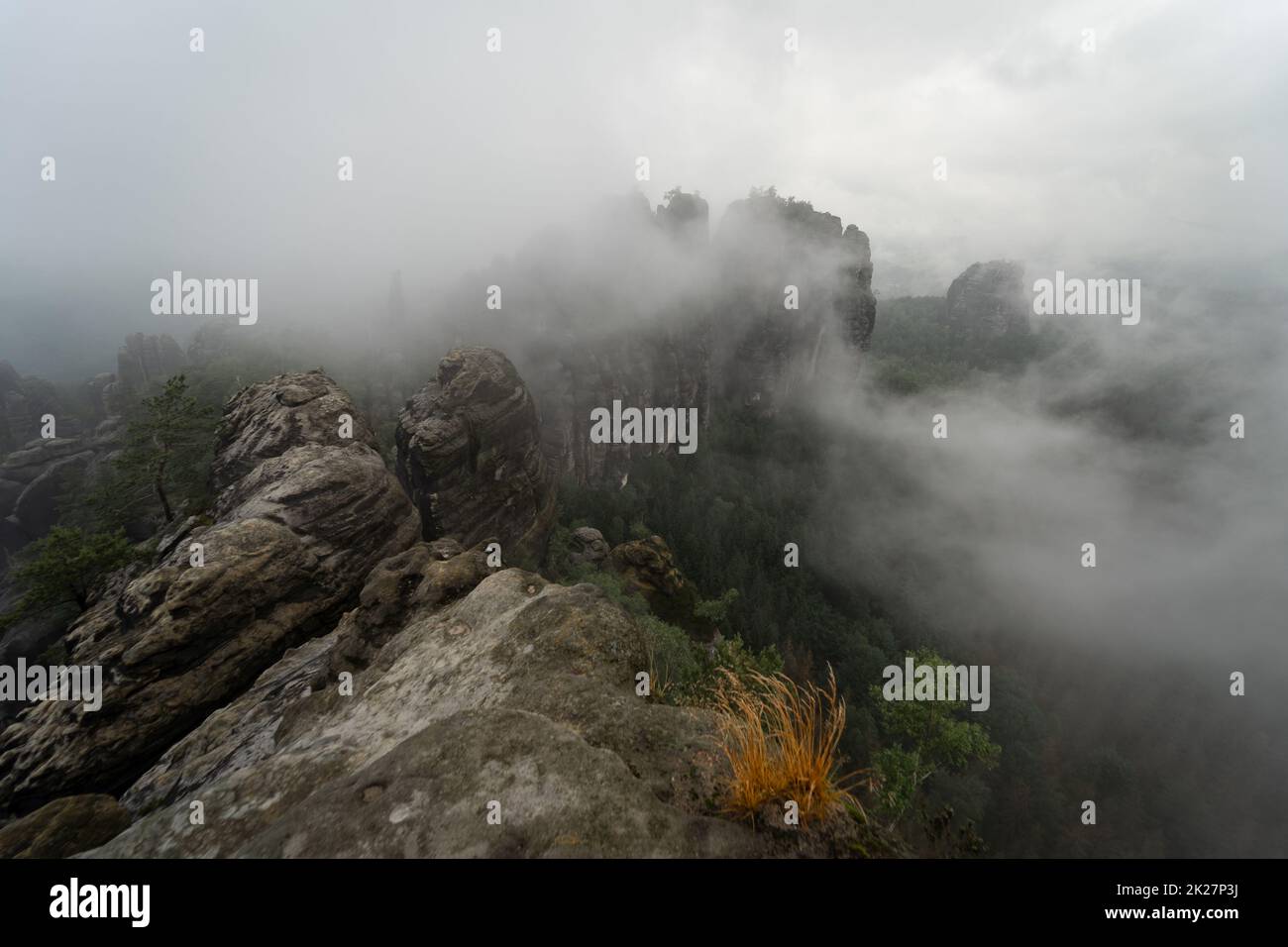 Ein früher bewölkter Morgen in den Bergen. Schrammsteine - eine Gruppe von Felsen ist eine lange, weit gestreckte, sehr zerklüftete Gruppe in den Elbsandsteinbergen in der sächsischen Schweiz in der DDR. Stockfoto