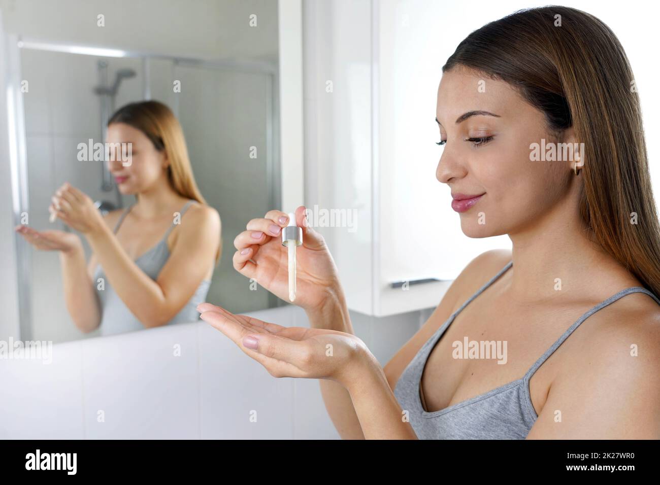Hautpflegeprogramm. Schöne Frau, die eine Pipette in der Hand hält, mit Serum-feuchtigkeitsspendenden Anti-Aging-Antioxidantien. Stockfoto