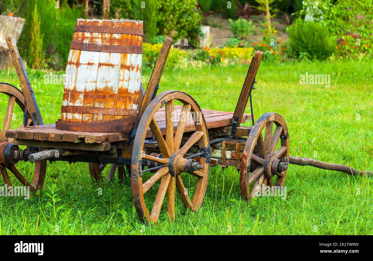 Ein alter Holzwagen mit einem Fass auf dem grünen Gras. Selektiver Fokus Stockfoto