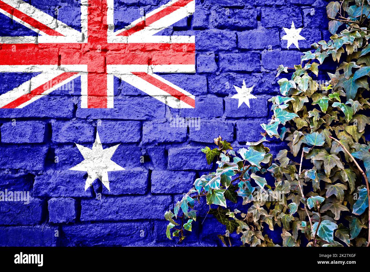 Australische Grunge-Flagge an Backsteinwand mit Efeu-Pflanze Stockfoto