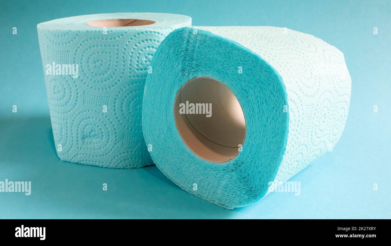 Blaue Rolle mit modernem Toilettenpapier auf blauem Hintergrund. Ein Papierprodukt auf einer Papphülle aus Zellulose für Sanitärzwecke mit Ausschnitten zum einfachen Abreißen. Geprägte Zeichnung Stockfoto