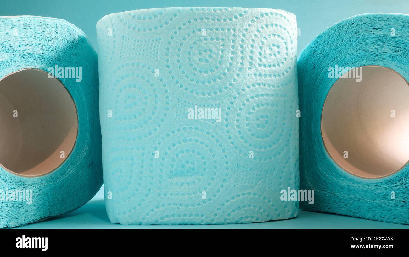Blaue Rolle mit modernem Toilettenpapier auf blauem Hintergrund. Ein Papierprodukt auf einer Papphülle aus Zellulose für Sanitärzwecke mit Ausschnitten zum einfachen Abreißen. Geprägte Zeichnung Stockfoto