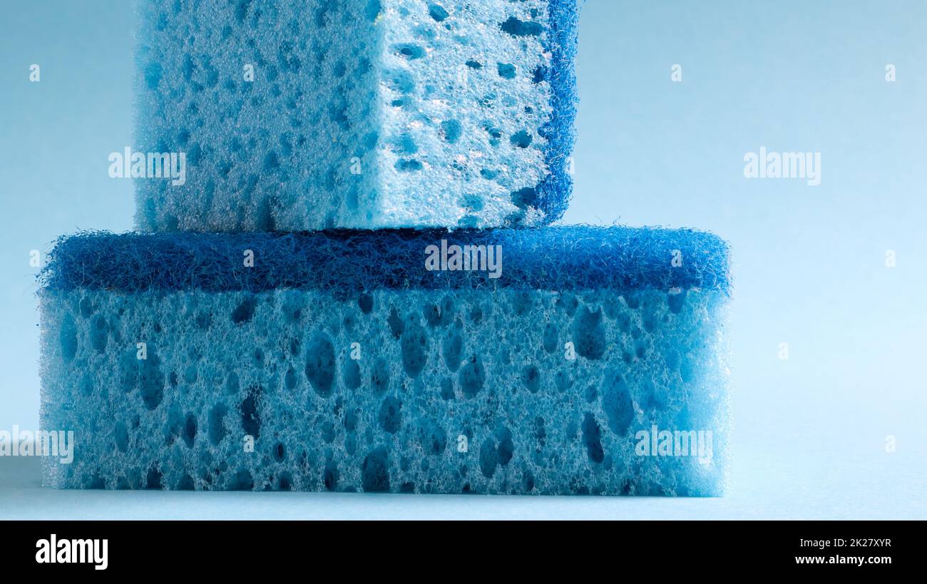 Zwei blaue Schwämme zum Waschen und Löschen von Schmutz, der von Hausfrauen im Alltag verwendet wird. Sie bestehen aus porösem Material wie Schaum. Reinigungsmittelrückhalt, wodurch Sie es wirtschaftlich ausgeben können Stockfoto