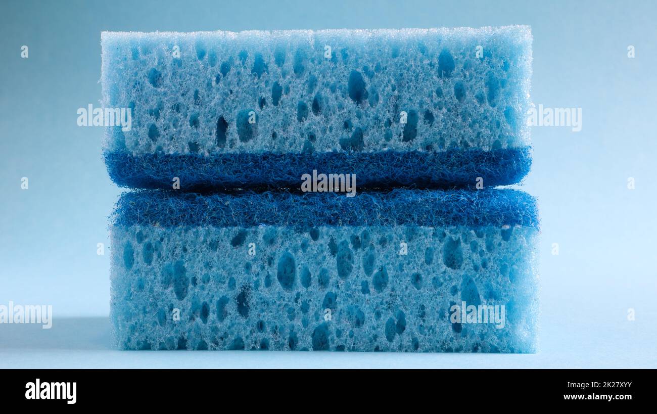 Zwei blaue Schwämme zum Waschen und Löschen von Schmutz, der von Hausfrauen im Alltag verwendet wird. Sie bestehen aus porösem Material wie Schaum. Reinigungsmittelrückhalt, wodurch Sie es wirtschaftlich ausgeben können Stockfoto