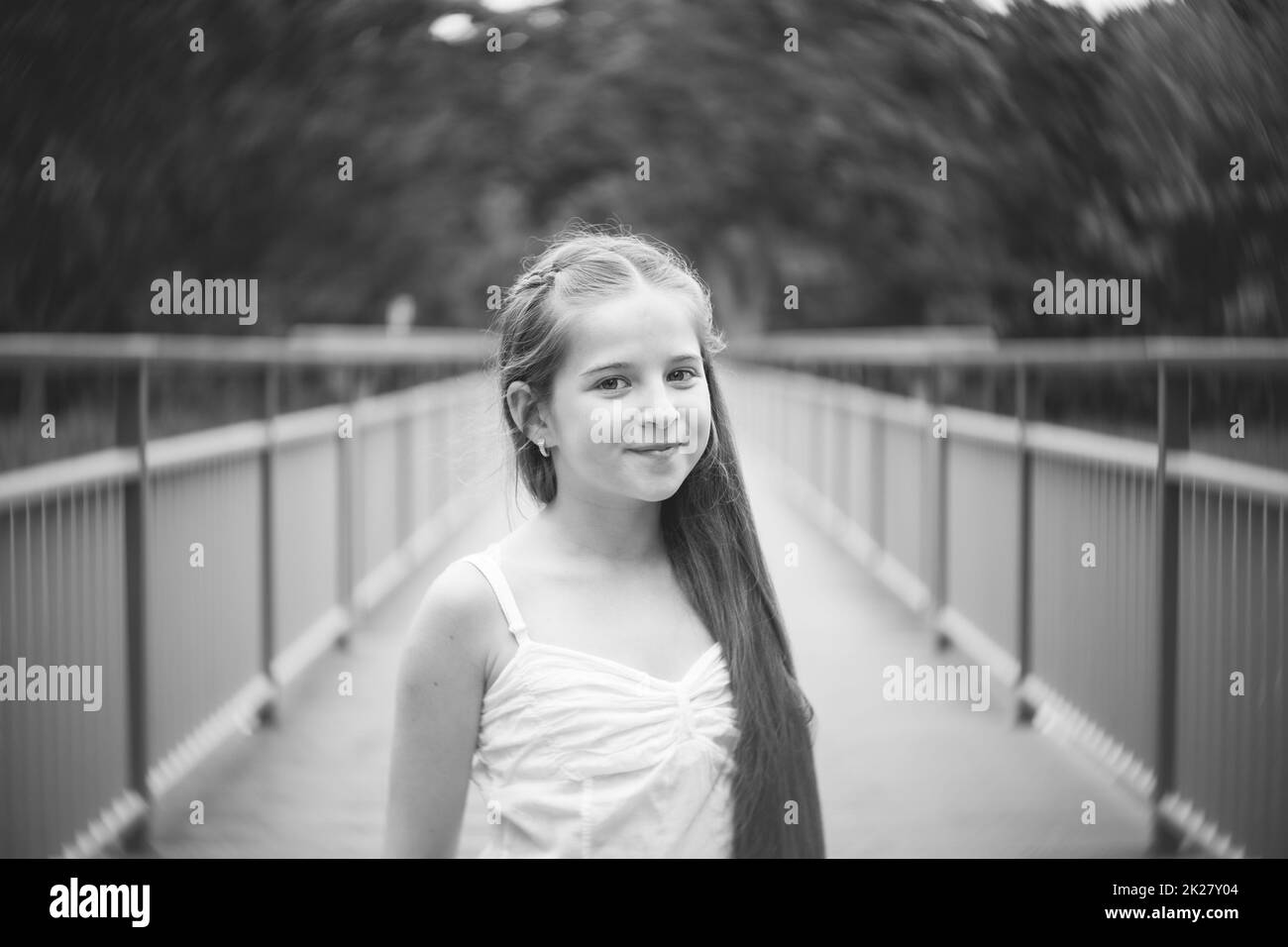 Portrait eines schönen Mädchens mit langen Haaren auf einer Brücke. Schwarz und weiß. Stockfoto