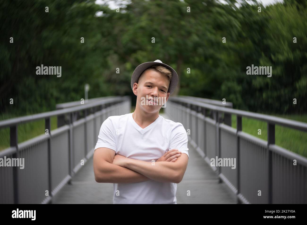 Porträt eines Teenagers, der auf einer Brücke steht. Natürliche Gesichtshaut, ohne Retusche. Stockfoto