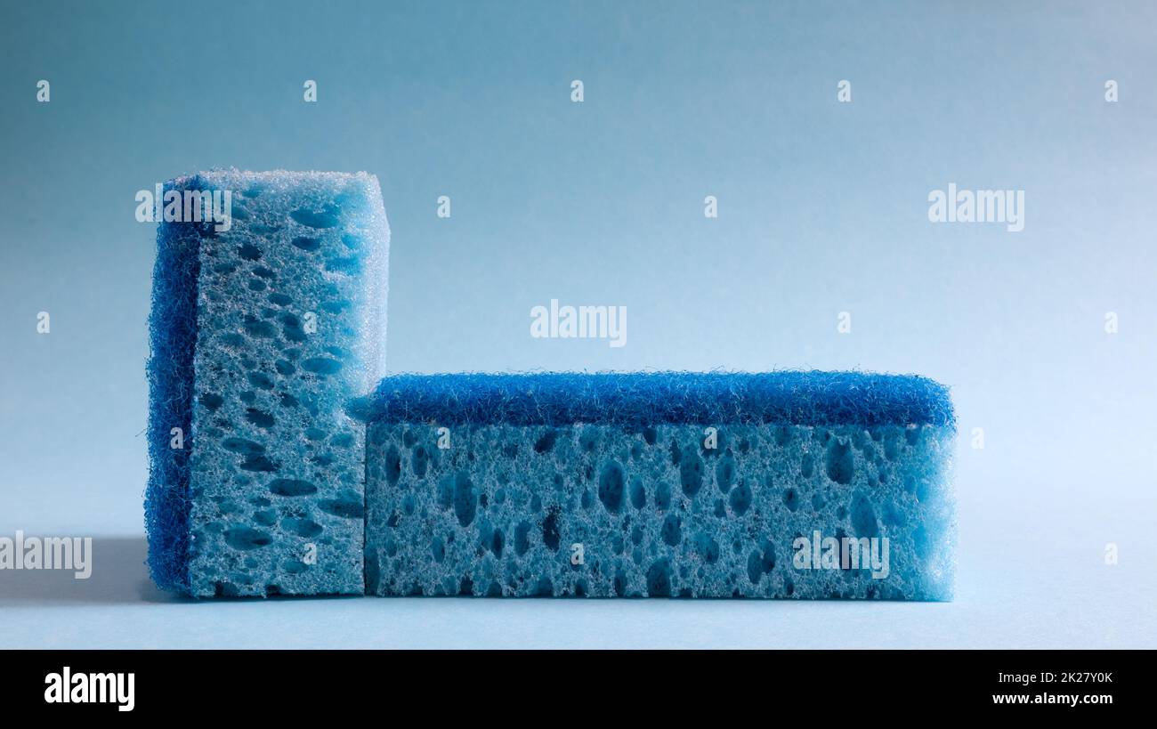 Zwei blaue Schwämme zum Waschen und Löschen von Schmutz, der von Hausfrauen im Alltag verwendet wird. Sie bestehen aus porösem Material wie Schaum. Reinigungsmittelrückhalt, wodurch Sie es wirtschaftlich ausgeben können Stockfoto