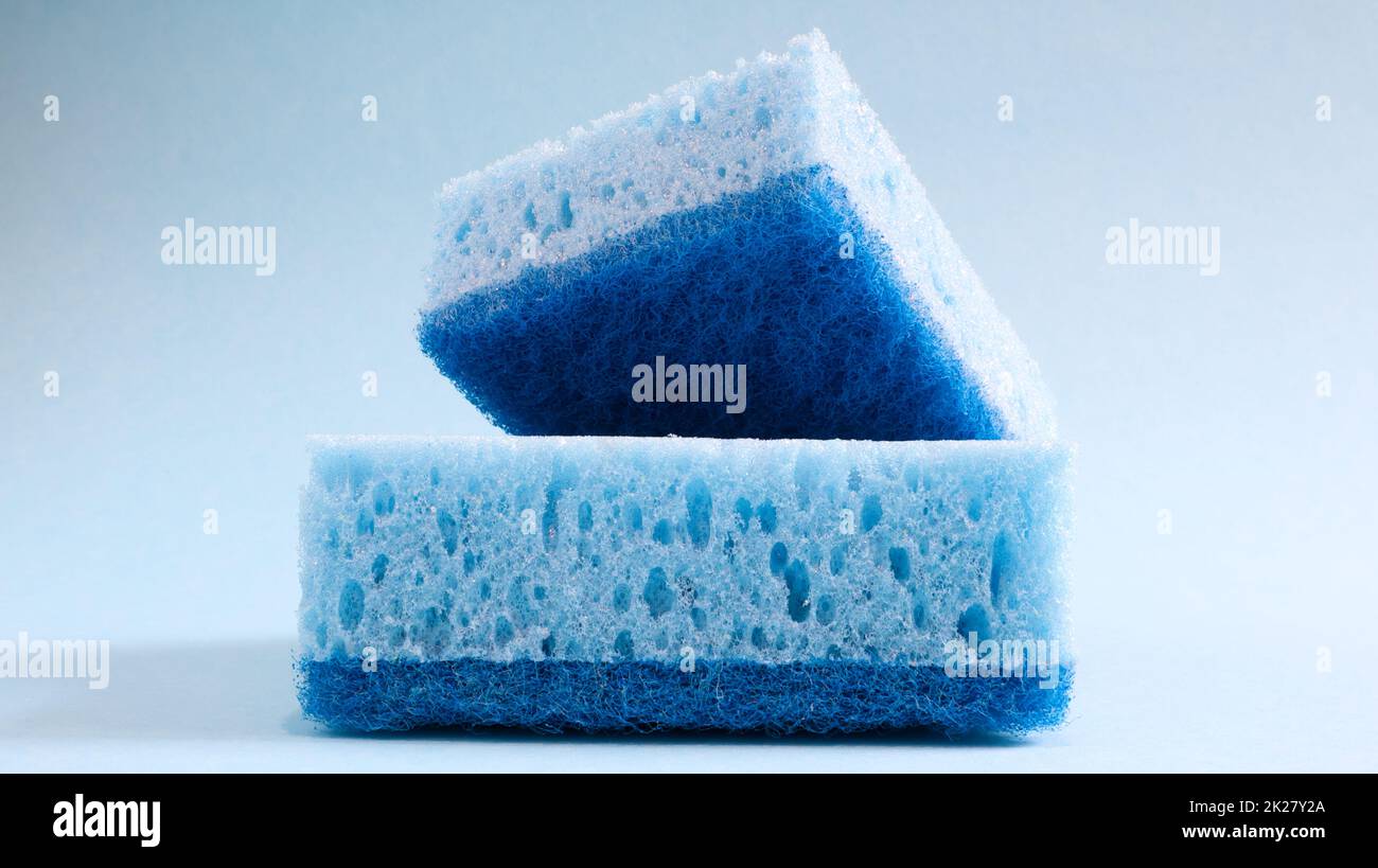 Zwei blaue Schwämme zum Waschen und Löschen von Schmutz, der von Hausfrauen im Alltag verwendet wird. Sie bestehen aus porösem Material wie Schaum. Reinigungsmittelrückhalt, wodurch Sie es wirtschaftlich ausgeben können Stockfoto
