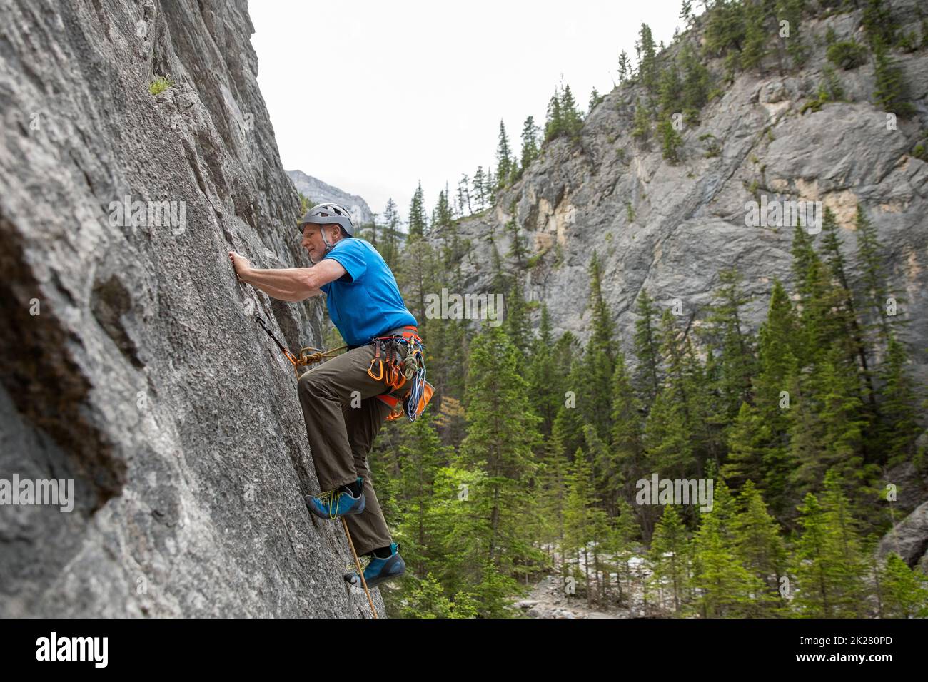 Älterer männlicher Bergsteiger, der die Felswand erklimmen hat Stockfoto