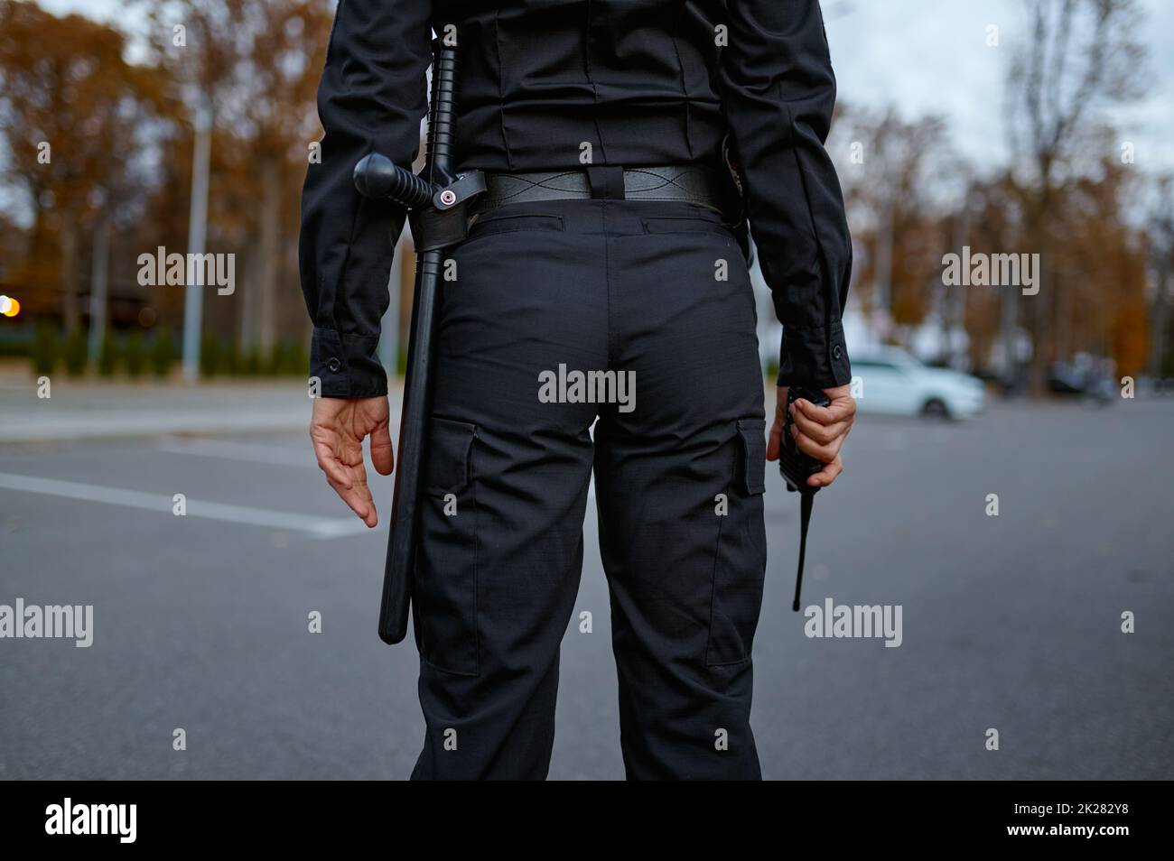 Polizistin mit Mittelteil und Walkie-Talkie-Rückansicht Stockfoto
