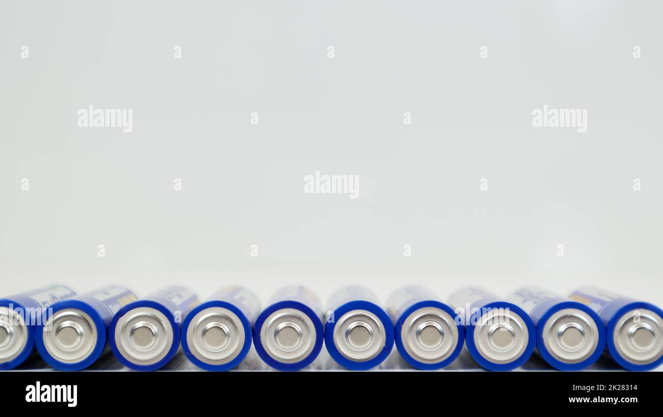 Viele AA-Alkali-Batterien auf weißem glänzendem Hintergrund mit Reflexion und einer Reihe angeordneter Kopien. Ukraine, Kiew - 7. Januar 2021. Stockfoto