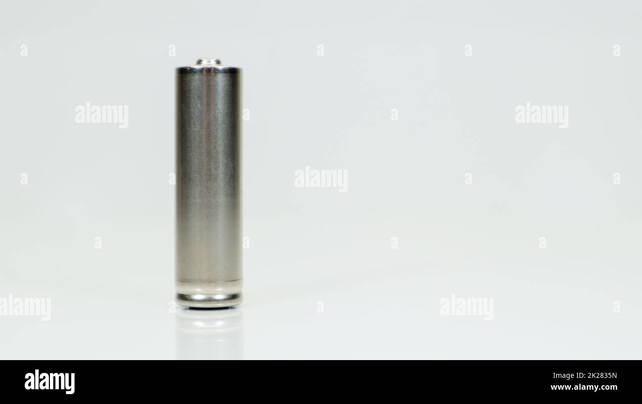 AA-Alkali-Mangan-Batterie auf weißem, glänzendem Hintergrund mit Reflexion. Schließen Sie eine leere Batterie mit Kopierraum. Stockfoto