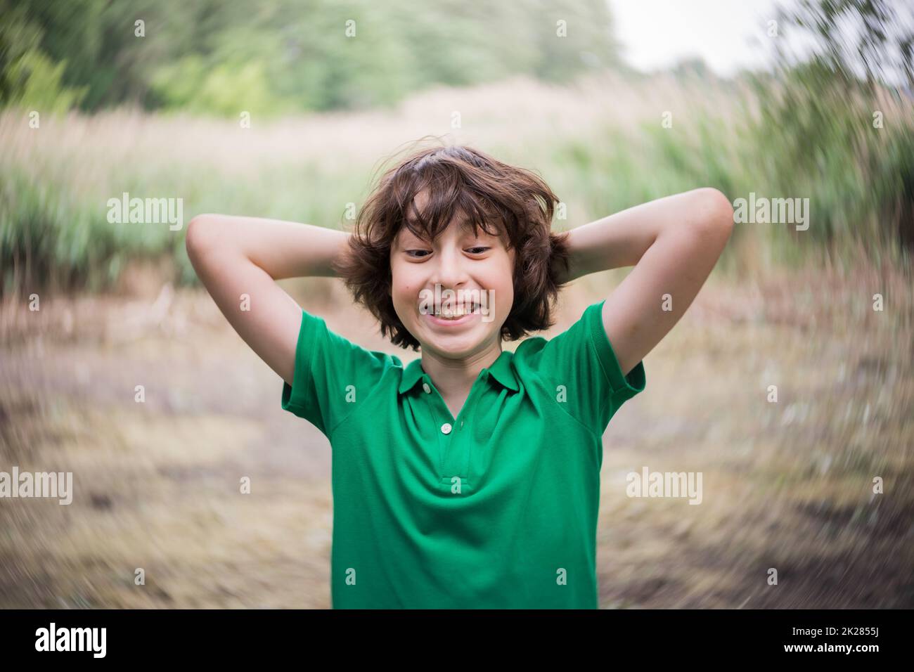 Porträt eines Jungen auf dem Hintergrund der Natur. Überrascht und freudig Grimasse. Stockfoto