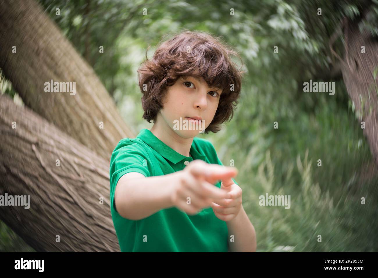 Porträt eines Jungen auf dem Hintergrund der Natur. Hand, die auf das Ziel zeigt. Stockfoto