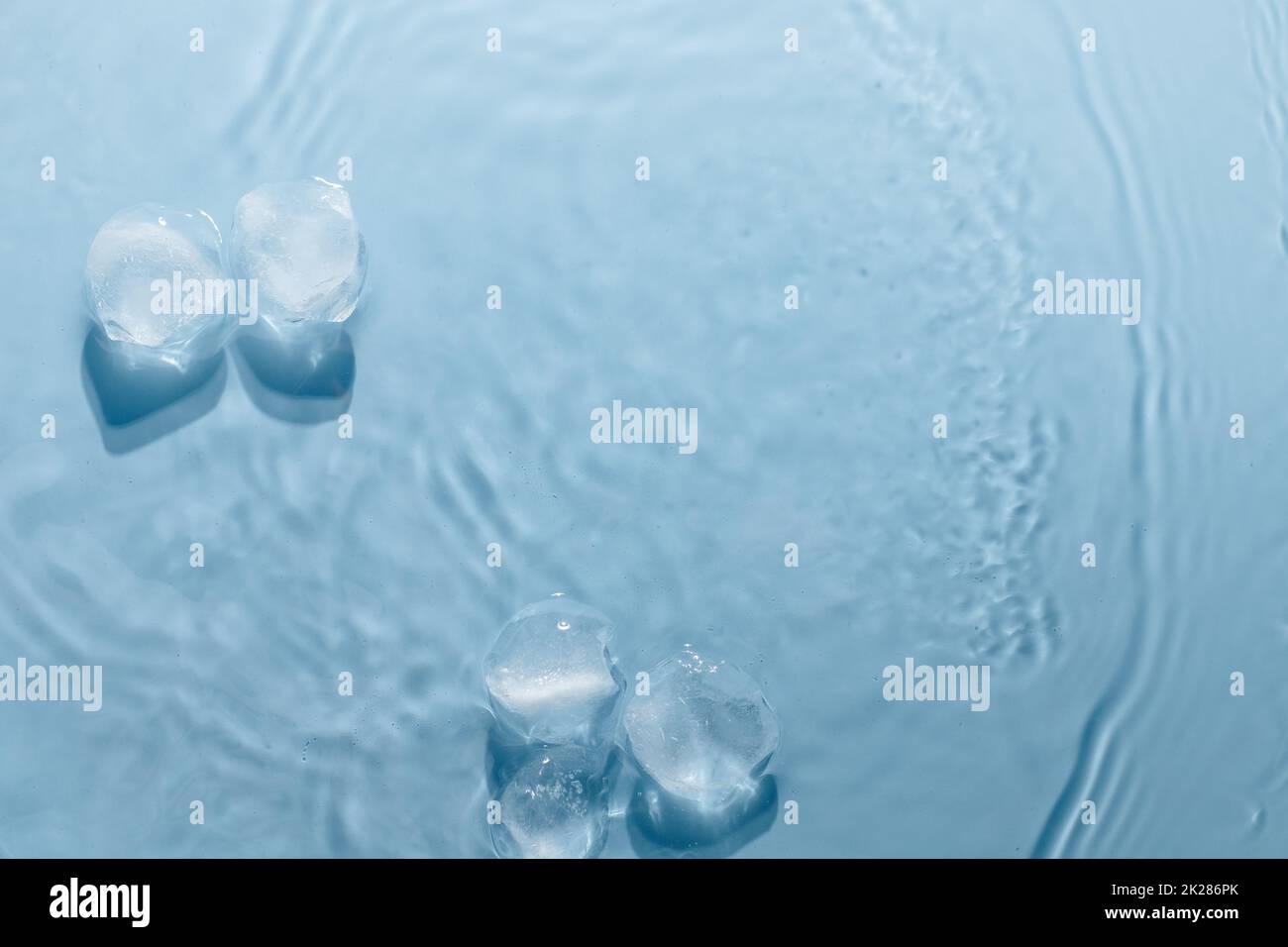 Eiswürfel mit Wassertropfen auf blauem Hintergrund, Draufsicht. Stockfoto
