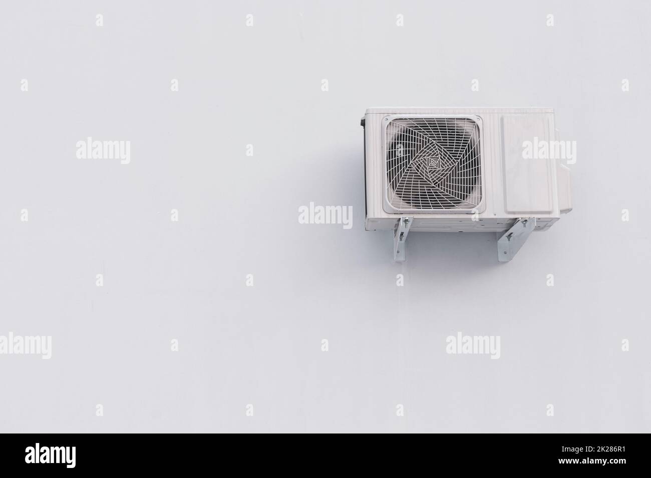 Klimaanlage im Freien, geteilte Systemeinheit an weißer Wand mit Kopierbereich Stockfoto Klimaanlage im Freien, geteilte Systemeinheit an weißer Wand mit Kopierbereich Stockfoto