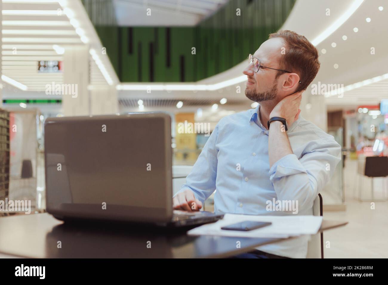 Nahaufnahme des gestressten, unglücklichen jungen Mannes mit wirklich schlimmen Nackenschmerzen, nach langen Arbeitsstunden, Studieren, isolierter weißer Hintergrund. Negative menschliche Emotionen, Gesichtsausdruck, Gefühle Stockfoto
