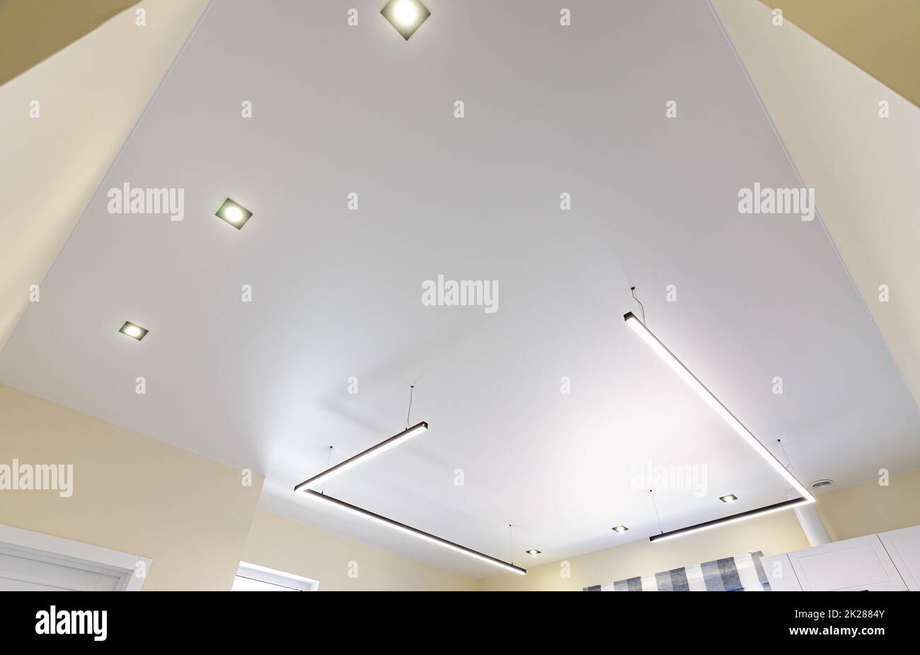 Moderne weiße, matte Stretchdecke mit Zonenbeleuchtung Stockfoto