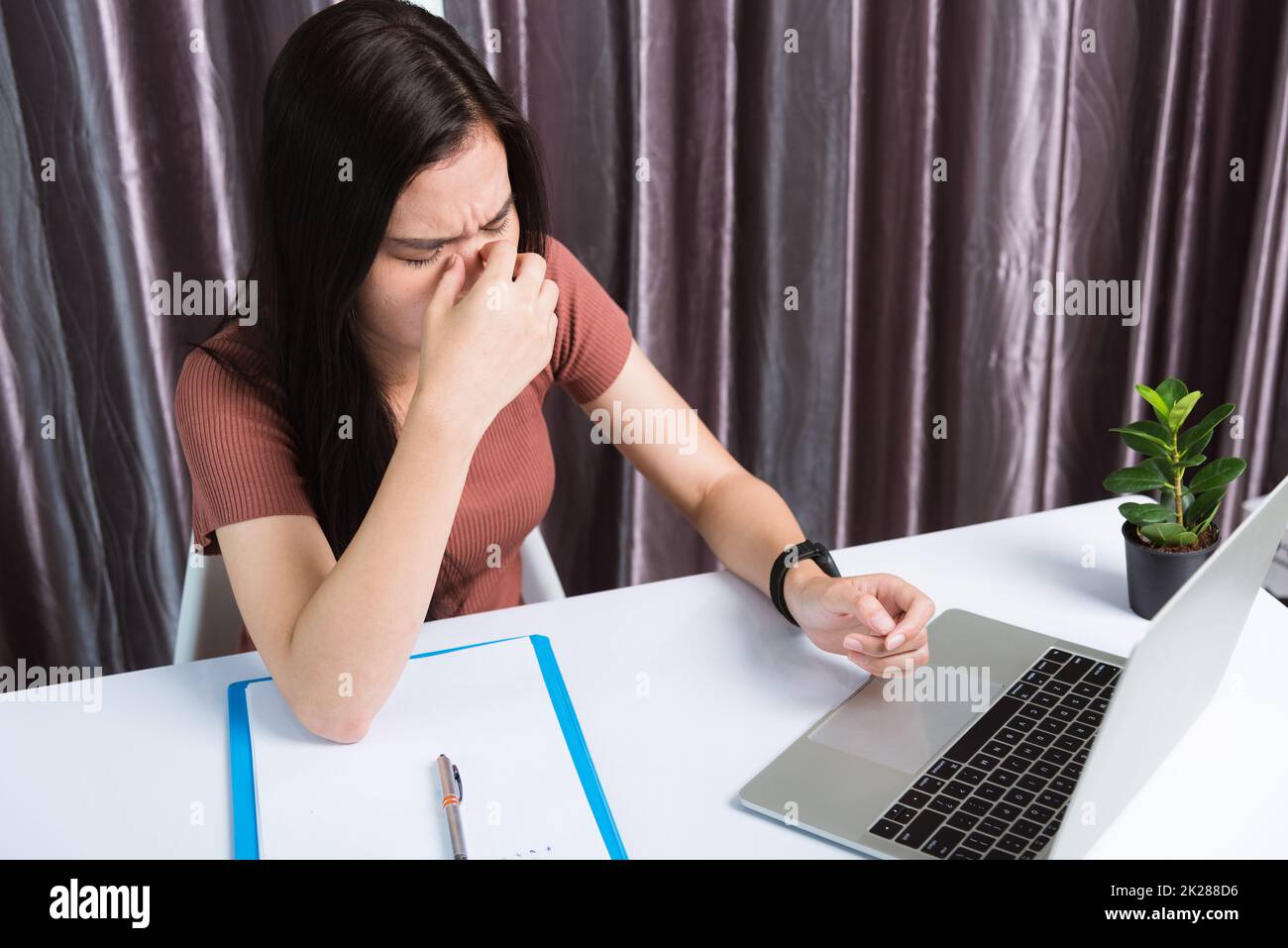 Geschäftsfrau, die sich müde fühlt, gestresst, halte seine Nase mit den Augen zu Stockfoto