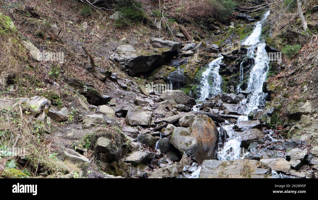 Wasserfälle in einem kleinen Canyon mit Steinwänden. Wunderschöne Kaskade in den Bergen. Der Fluss in den Karpaten im Bergherbstwald. Malerische Aussicht, die Bewegung des Wassers. Stockfoto