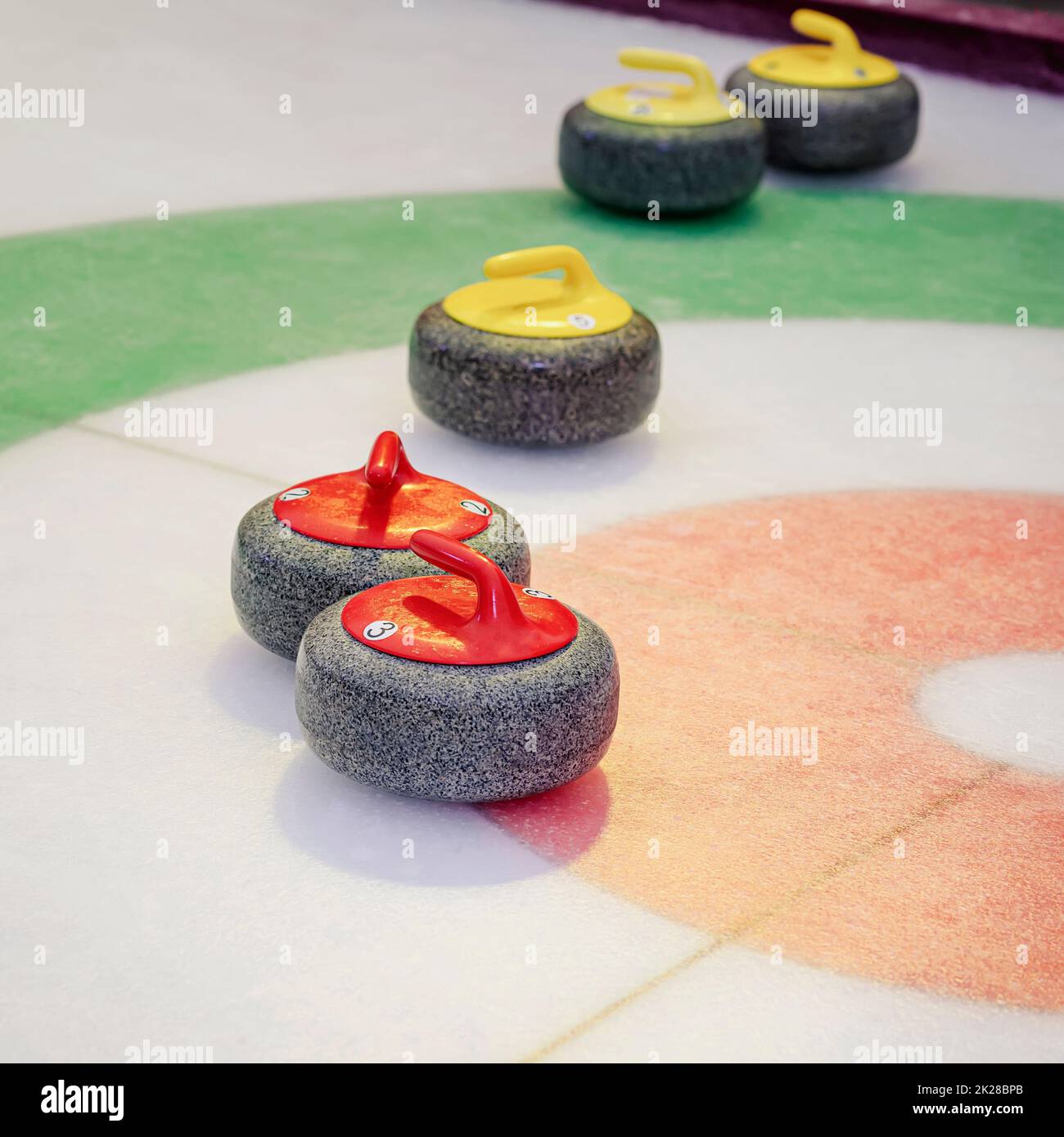 Eisbahn und Granitstein. Eisstockschießen roter Steine auf dem Spielfeld auf der Eisbahn während des Wettkampfs Stockfoto