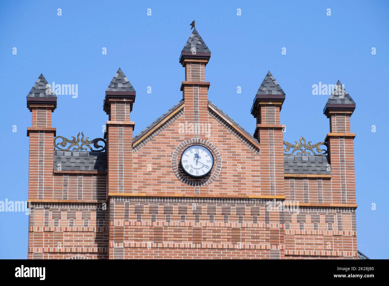 Uhr an der Wand eines Ziegelgebäudes. Braunes Backsteingebäude mit Boshni und Öffnungszeiten. Stockfoto