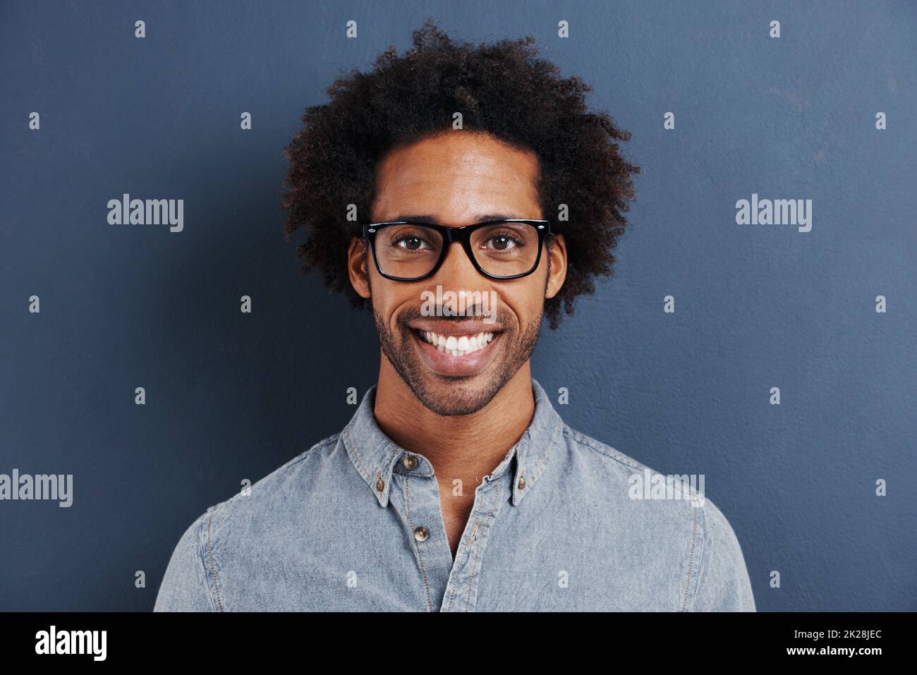 Ich lasse mich nicht von Etiketten definieren. Porträt eines hübschen jungen Mannes mit Brille auf grauem Hintergrund. Stockfoto