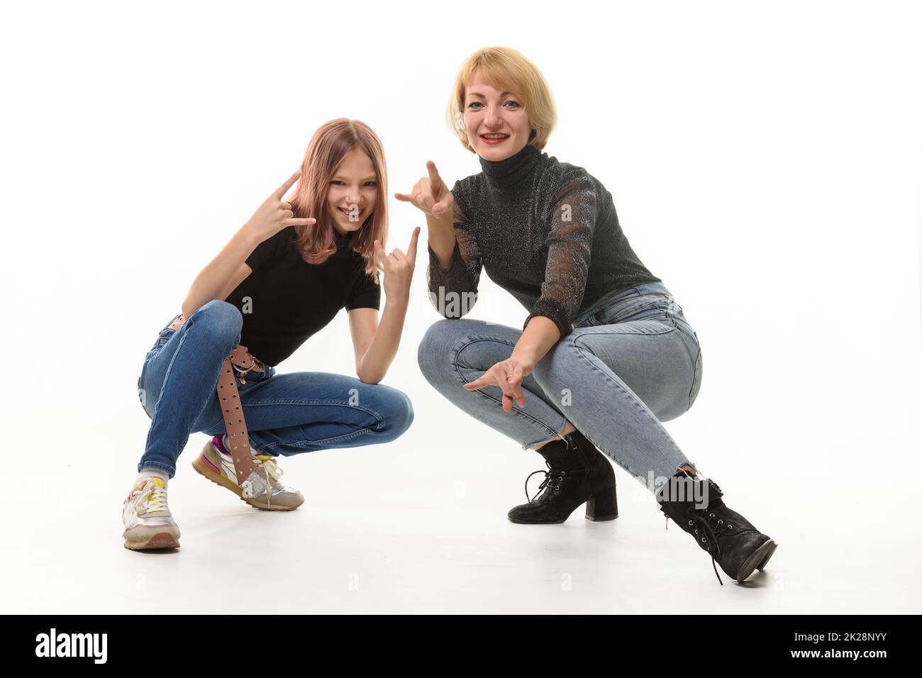 Mutter und Tochter Teenager knieten nieder und zeigen fröhlich Jugendgesten im Rahmen Stockfoto