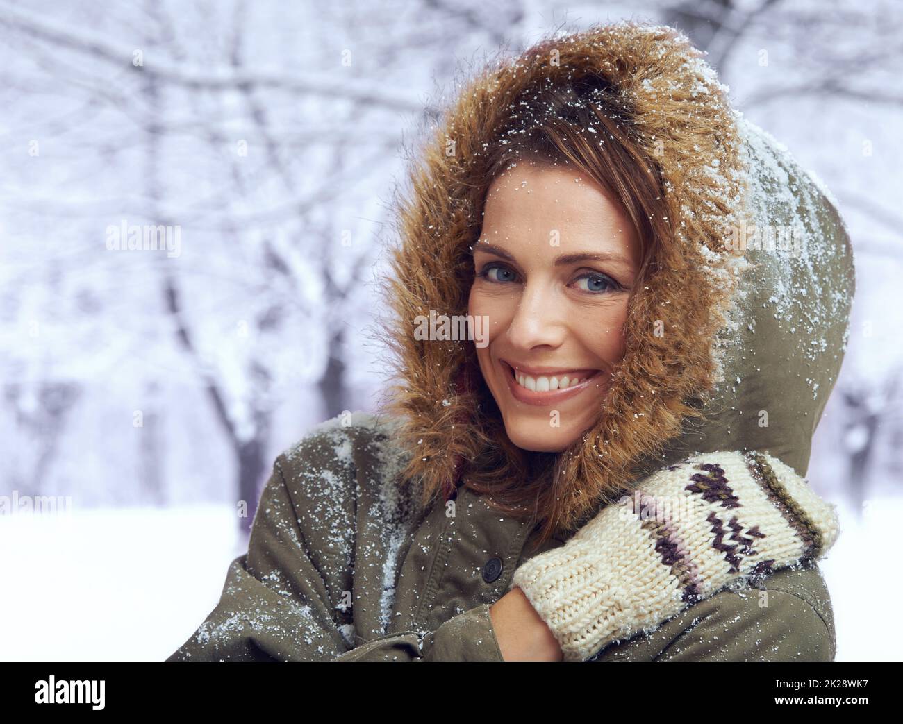 Liebe den ersten Schneefall. Eine attraktive Frau, die sich draußen im Schnee genießt. Stockfoto