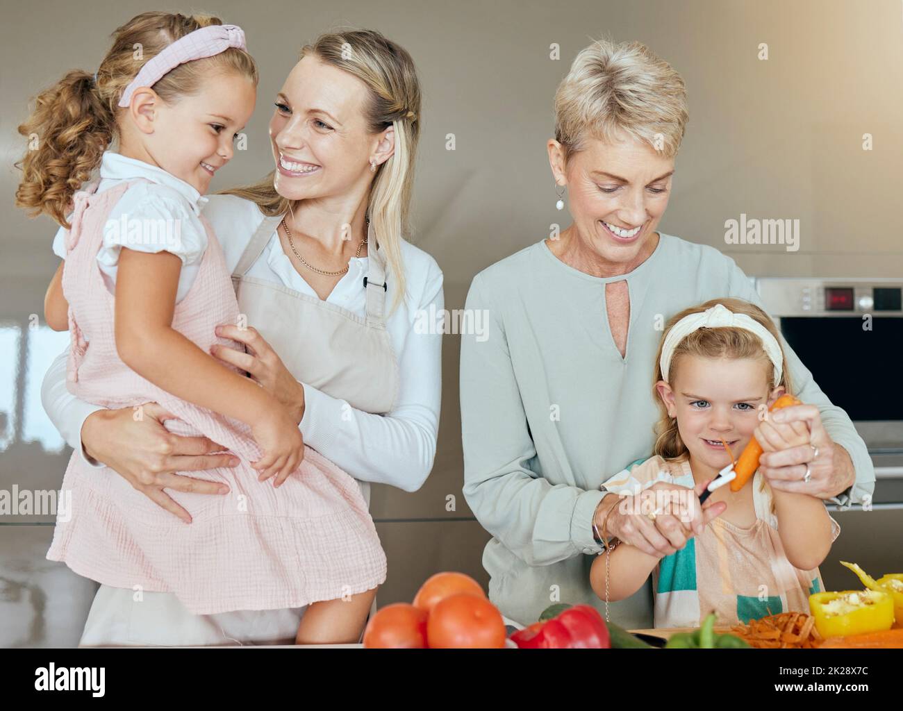 Familie Kochen, glückliches Mittagessen und Kinder helfen mit Mutter und Großmutter mit einem gesunden Frühstück in der Küche. Mama und Oma unterrichten Kinder mit Stockfoto