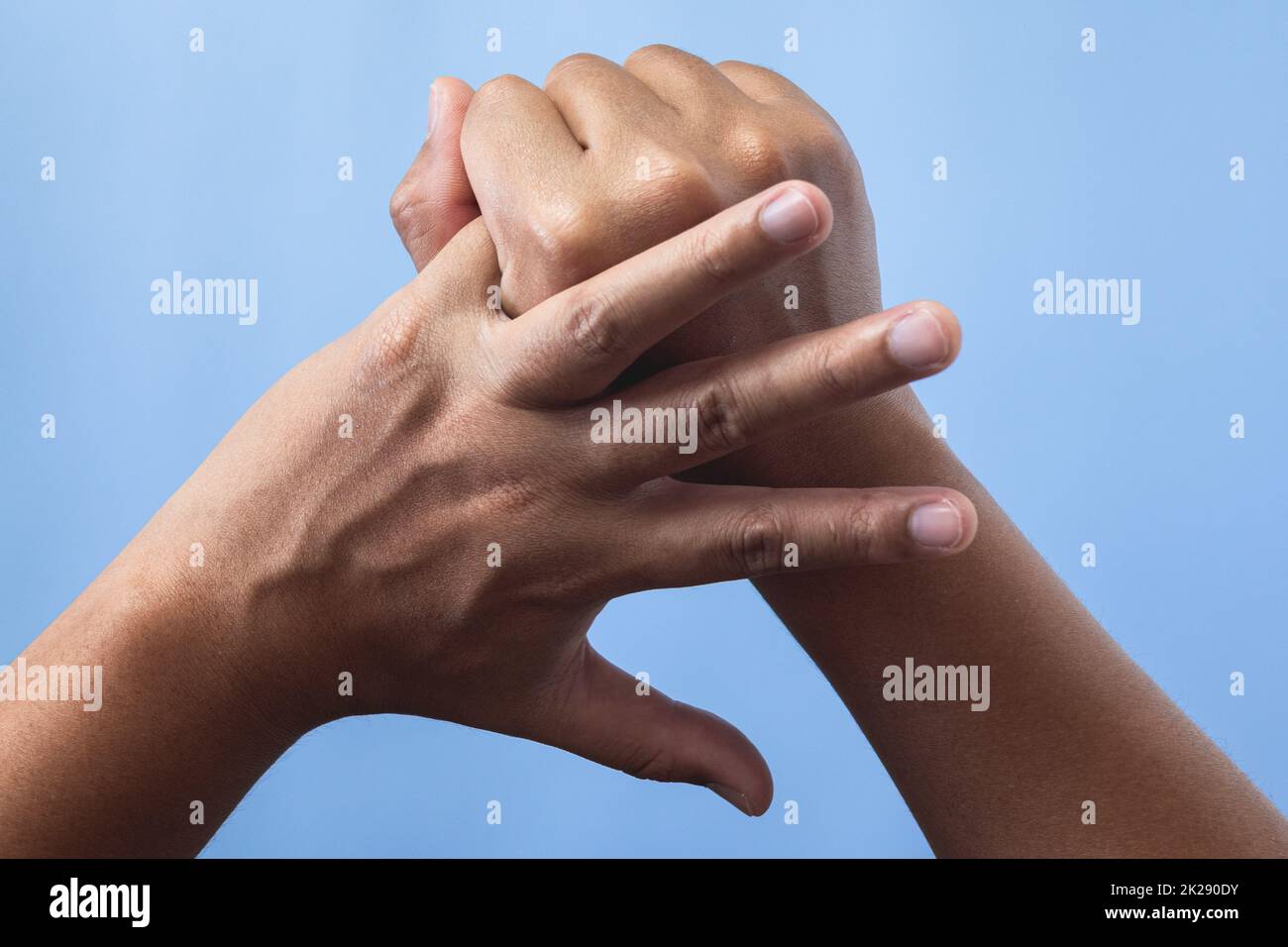 Konzept des Office-Syndroms. Der kleine Finger wird nach der Arbeit massiert und gestreckt. Nahaufnahme Isolieren auf blauem Hintergrund. Rückseitenansicht. Stockfoto