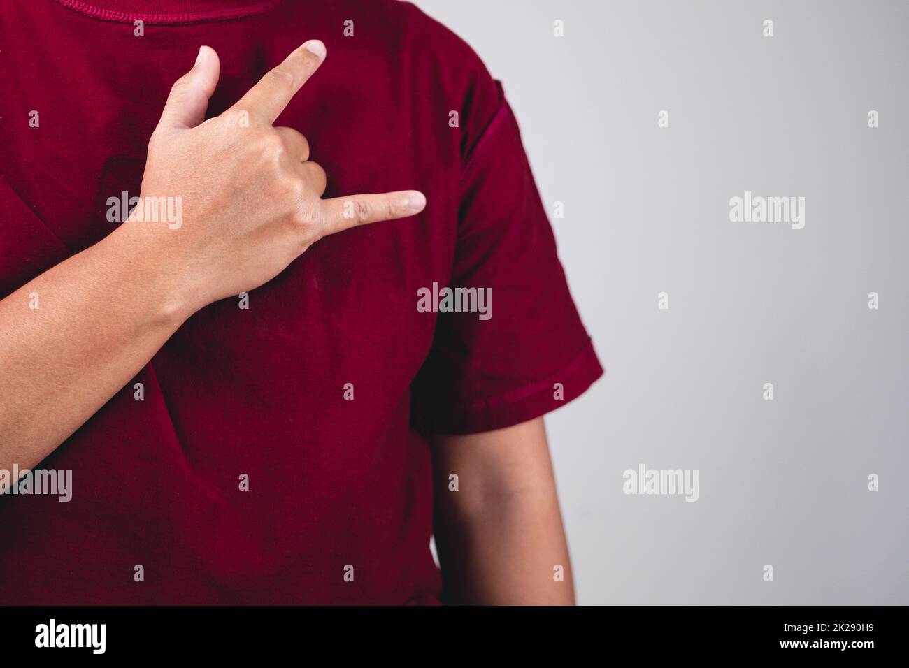 Zeichen der Selbstliebe. Umarmen Sie sich selbst und positives Denken. Der Mann mit rotem Hemd in mittlerer Nahaufnahme. Platz für Nachrichten, Wörter und Texte kopieren. Stockfoto