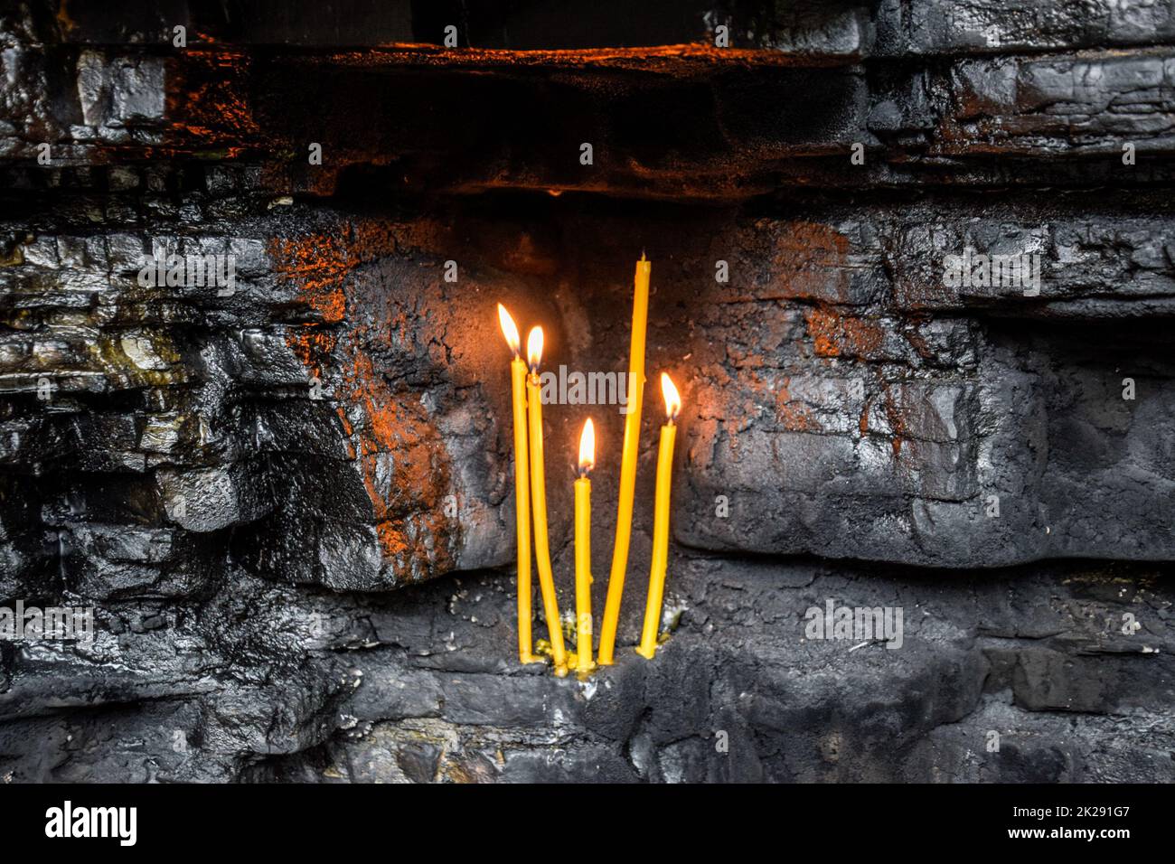 Wachs Kirche Kerzen in Rock Nischen. Heiligen Ort Stockfoto