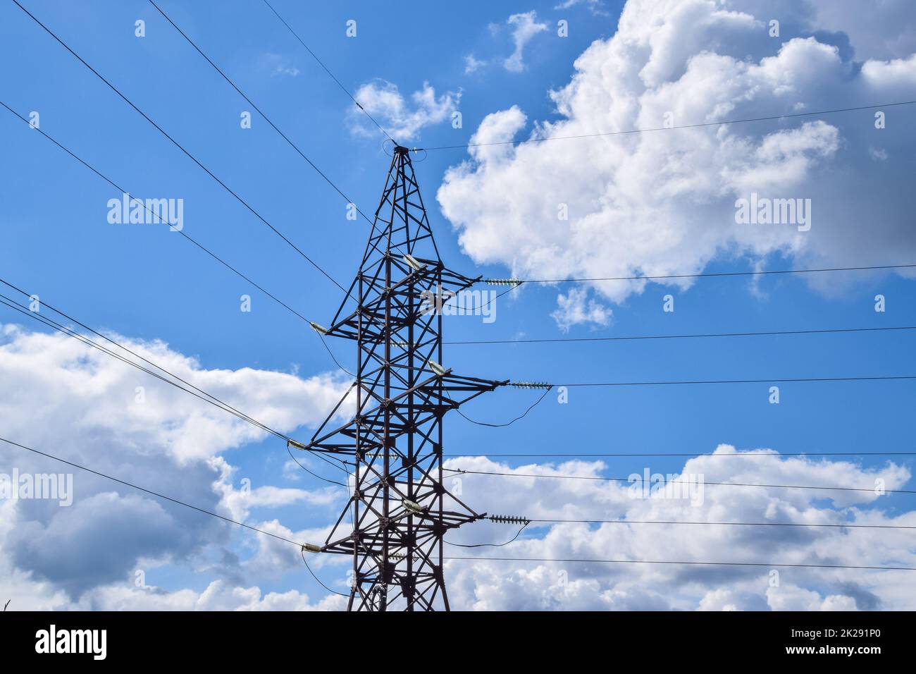 Unterstützt Hochspannungsleitungen gegen den blauen Himmel mit Wolken. Elektroindustrie Stockfoto
