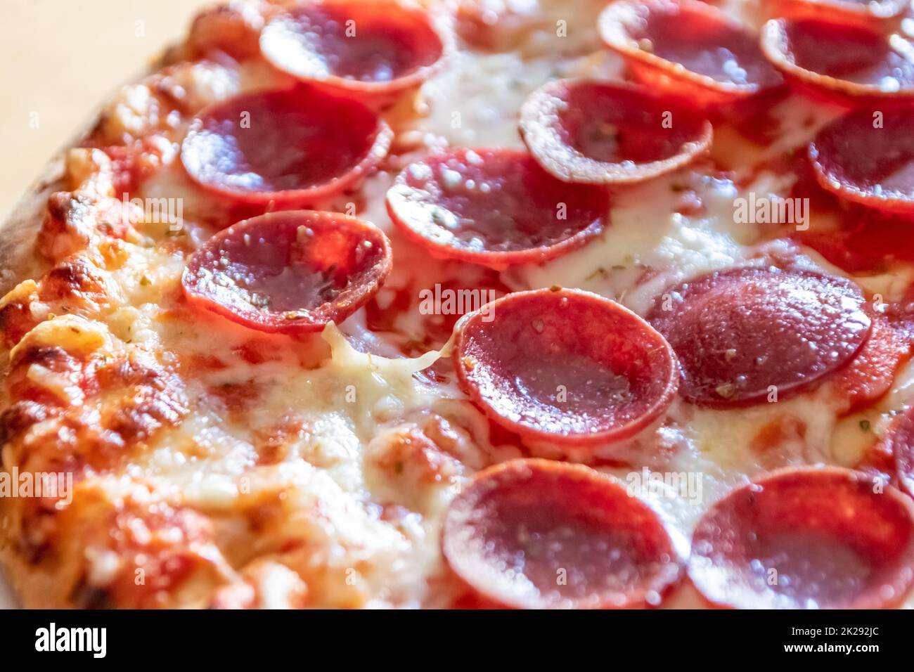 Köstliche Salami-Pizza aus nächster Nähe mit Käse und Tomatensauce als köstliche italienische Delikatesse und Diät-Fast-Food-Mittagessen für hungrige Teenager, die ungesunde nahrhafte Snacks in Stücken essen Stockfoto