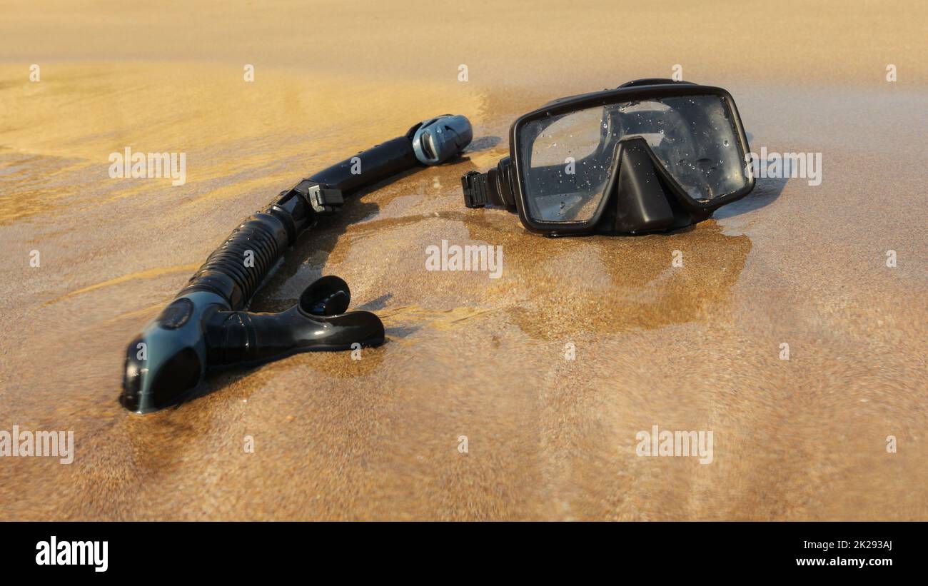 Schwarzer Schnorchel und Taucherbrille auf feinem Sandstrand. Durch nasses objektiv Wasser zu betonen. Stockfoto