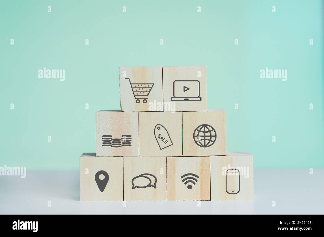 Holzwürfel mit Online-Shopping und Marketing-Symbol auf Hintergrund und Kopierraum. Stockfoto