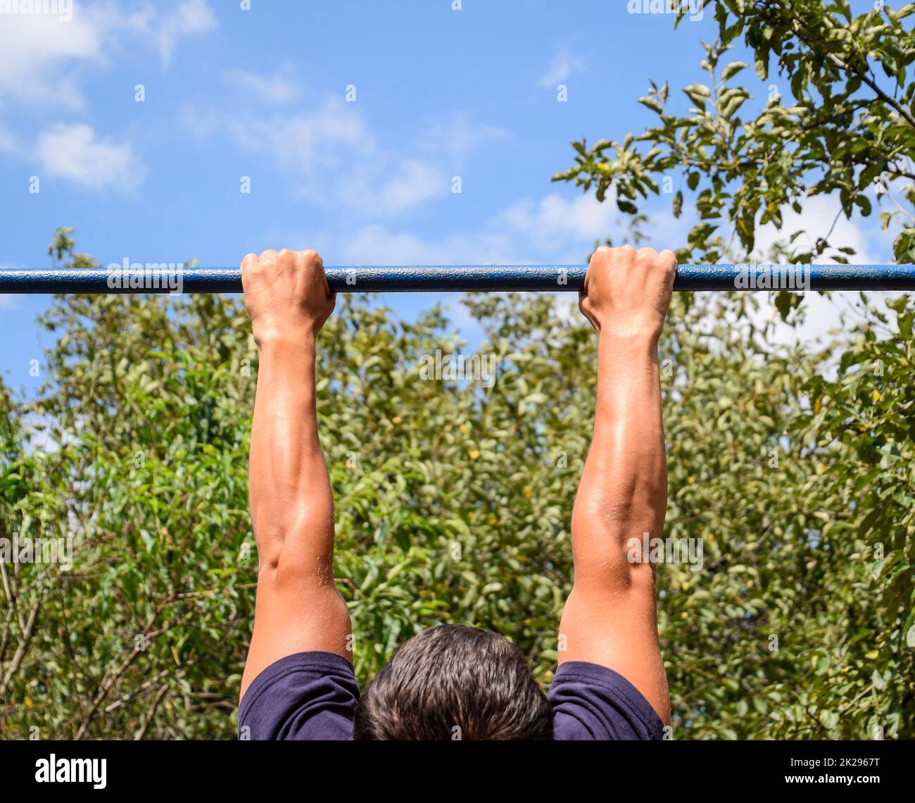 Hände auf die Bar zu schließen. Der Mann zieht sich an der Bar. Sport an der frischen Luft. Horizontale Leiste. Stockfoto