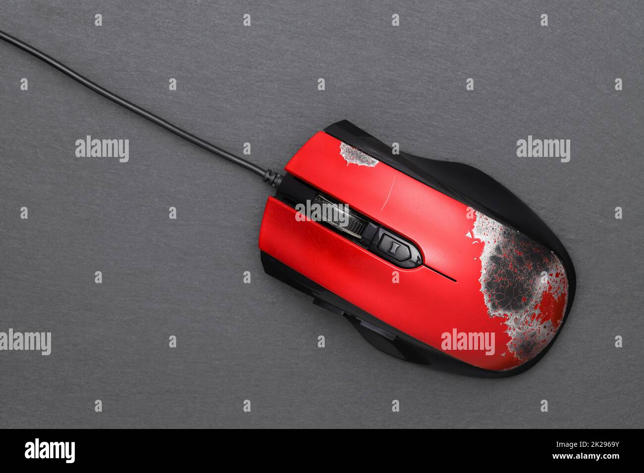 Defekte Computermaus mit Verbindungskabel auf dunkelgrauem Hintergrund Stockfoto