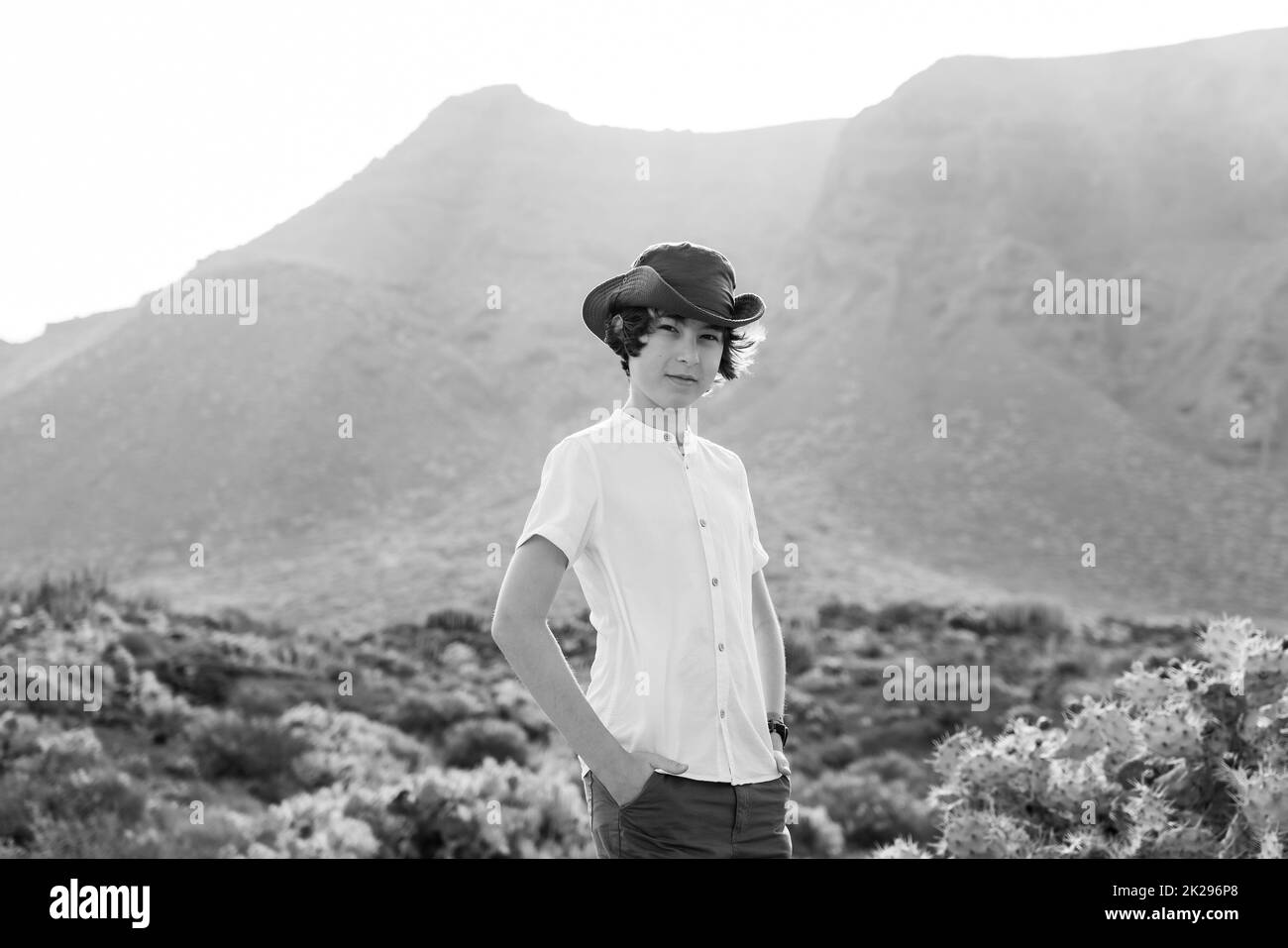 Porträt eines Teenagers vor dem Hintergrund der Klippen von Los Gigantes. Blick vom Kap Teno. Teneriffa. Kanarische Inseln. Spanien. Schwarz und Weiß. Stockfoto