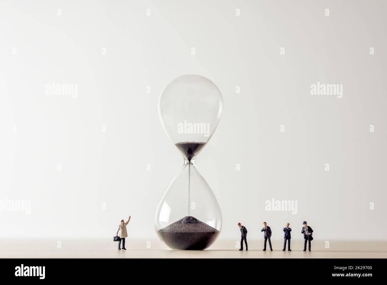 Konzeptbild von Geschäftsleuten, die auf Stundenglas schauen Stockfoto