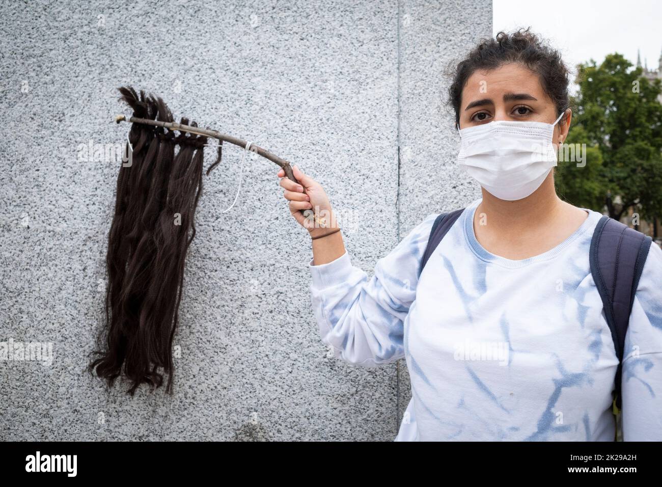 London, Großbritannien. 22. September 2022. Eine Frau mit einem Rest von rasierten Haaren während eines Protestes auf dem Parliament Square durch Iraner, die in London leben, als sie auf die Nachricht vom Tod reagierte, am 16. September von Mahsa Amini, einer 22-jährigen kurdischen Frau, die in Polizeigewahrsam in Teheran starb. Angeblich wurde sie von der iranischen Moralpolizei festgenommen, weil sie ein Kopftuch des Hijab auf „unangemessene“ Weise trug. Im Iran finden Proteste statt und der Zugang zum Internet und zu den sozialen Medien wird nun eingeschränkt. Kredit: Stephen Chung / Alamy Live Nachrichten Stockfoto