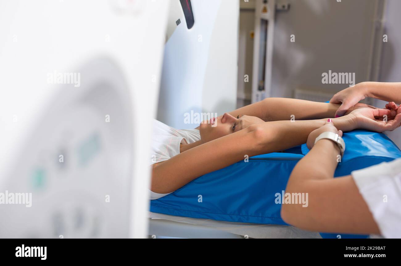 Hübsche, junge Frau, die eine computerisierte axiale Tomographie (CAT) durchläuft Scan medizinische Untersuchung/Untersuchung in einem modernen Krankenhaus (farbiges Bild, flacher DOF) Stockfoto