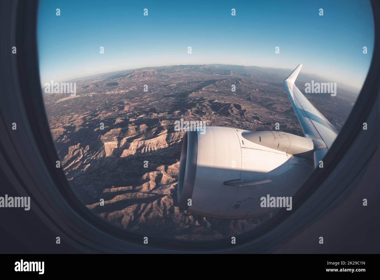 Blick auf die bergigen Fenstersitze aus dem Flugzeug Stockfoto