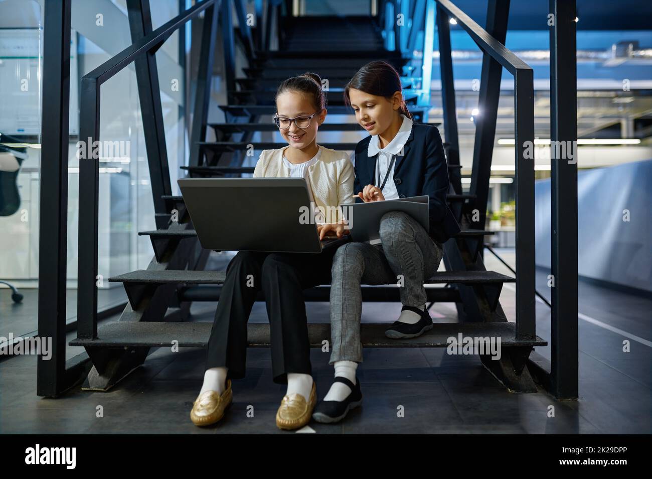 Zwei Geschäftskinder, die zusammen auf Treppen arbeiten Stockfoto