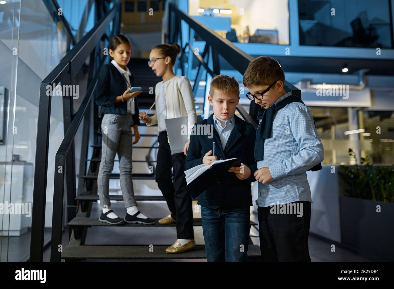 Gruppe von Kindern Geschäftsleute im Gespräch auf Treppe Stockfoto