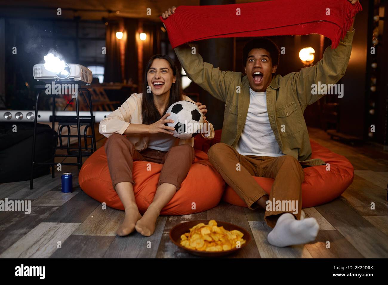 Paar schauen sich Fußballspiele auf dem Heimkino-Projektor an Stockfoto